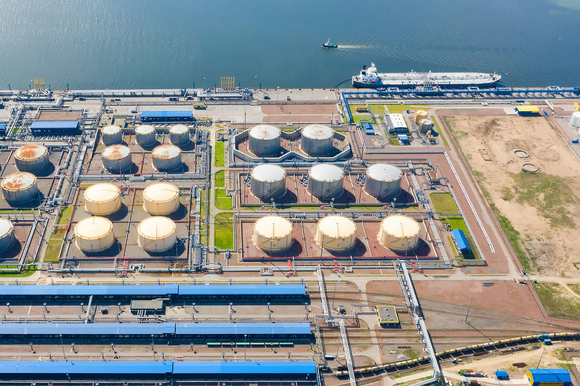 Representative tank farm with rail loading facilities and a tanker at the berth